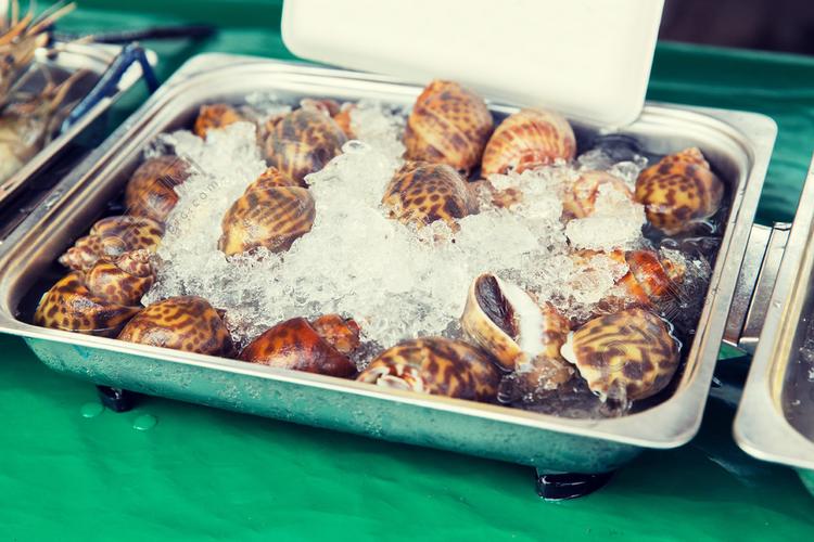 烹饪,亚洲厨房,销售和食品的概念— —冷冻的蜗牛或海鲜在街边市场上